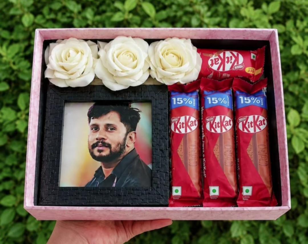 Photo frame, white roses, and chocolates in a pink gift box